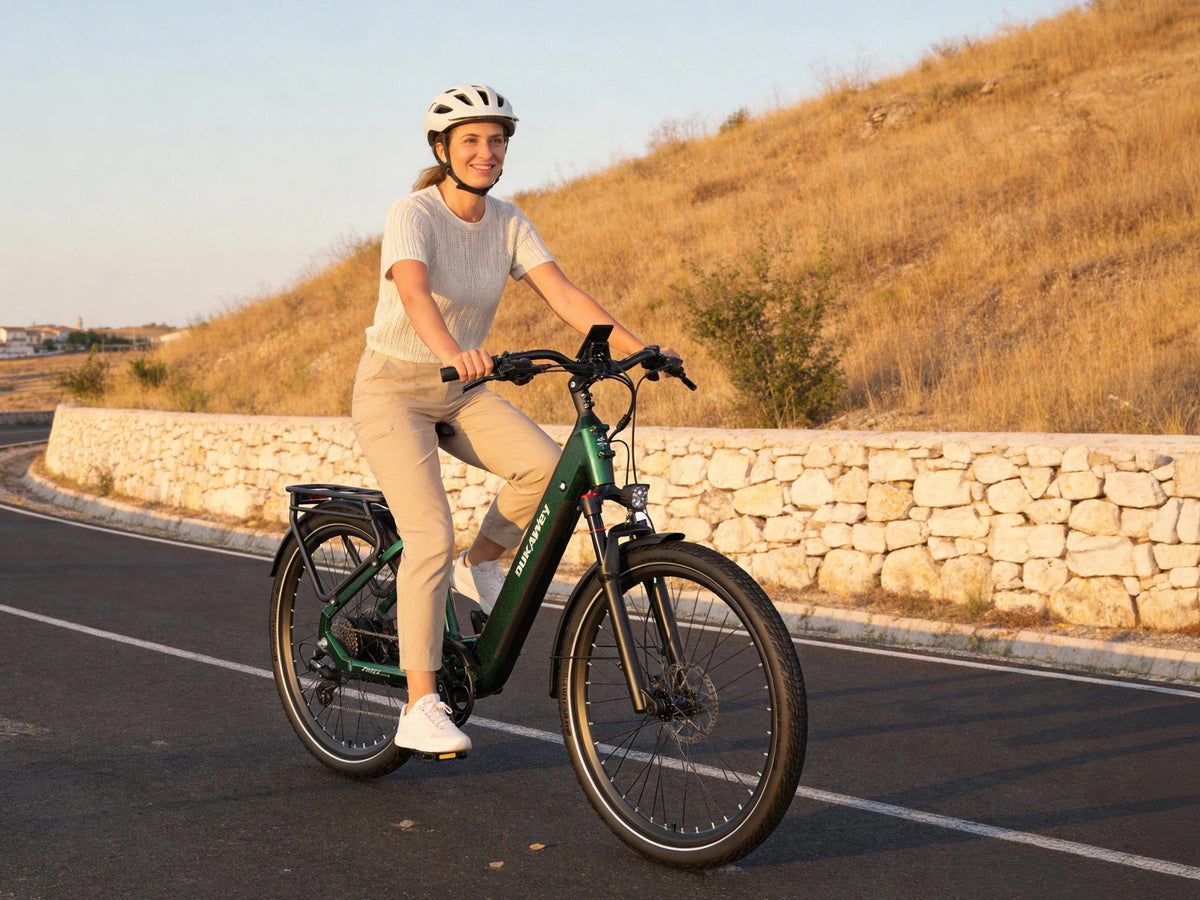 Woman riding a green Dukawey FUGL Pro beside a stone wall